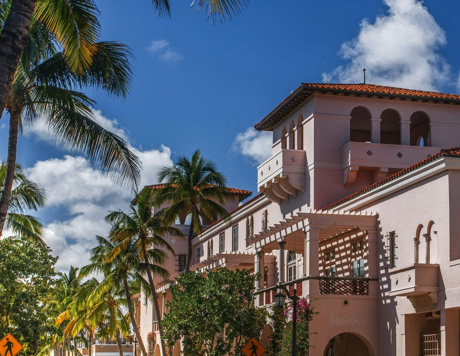A pink Mediterranean arcade and palms in Palm Beach